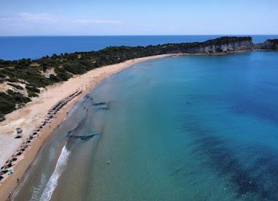 A protected beach on Zakynthos' southern coast, where golden sands meet turquoise waters and endangered loggerhead turtles find a safe haven.