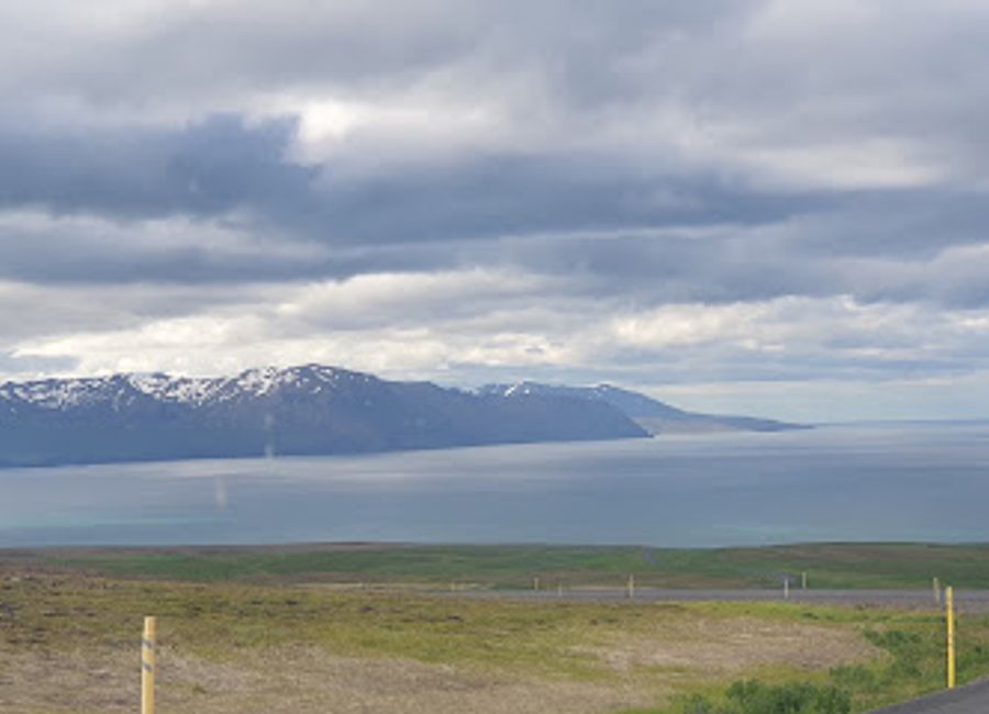 Experience the stunning panoramic views of Husavik, where charming townscapes meet majestic snow-capped mountains for an unforgettable Icelandic adventure.