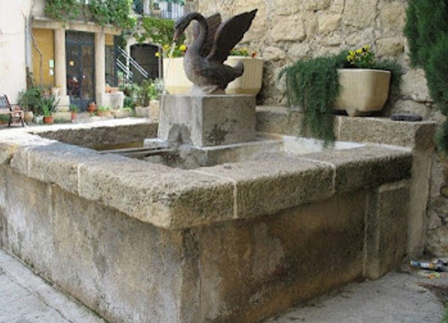 Experience the serene beauty of La Fontaine du Canard, a picturesque fountain in the charming village of Lauris, France.