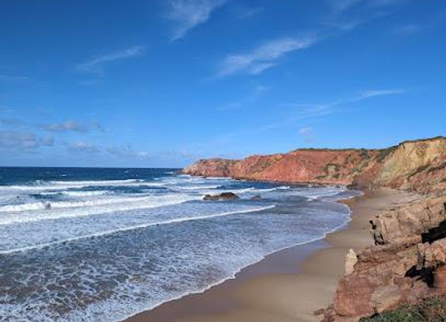 Discover the stunning Praia do Amado in Aljezur, Portugal, where golden sands meet exhilarating surf and breathtaking natural beauty.