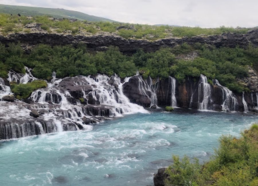 Discover the ethereal beauty of Hraunfossar Waterfall, where cascading waters and stunning landscapes create Iceland's hidden gem.
