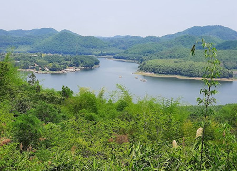 Experience the serene beauty of Huai Krathing Reservoir Viewpoint in Loei, Thailand, where lush mountains meet tranquil waters for unforgettable views.