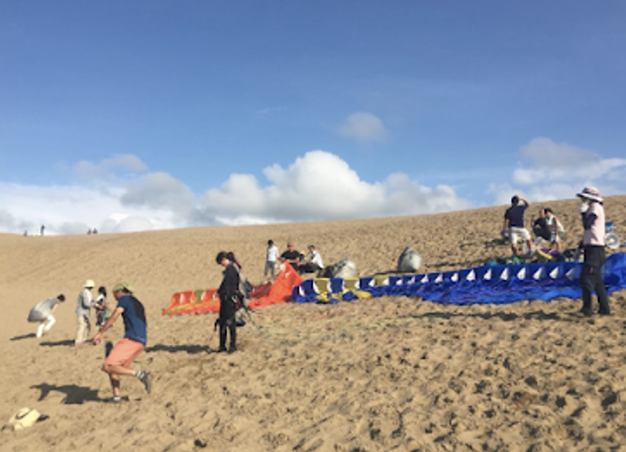 Experience the exhilarating freedom of paragliding over Japan's breathtaking Tottori Sand Dunes, a unique adventure for every traveler.