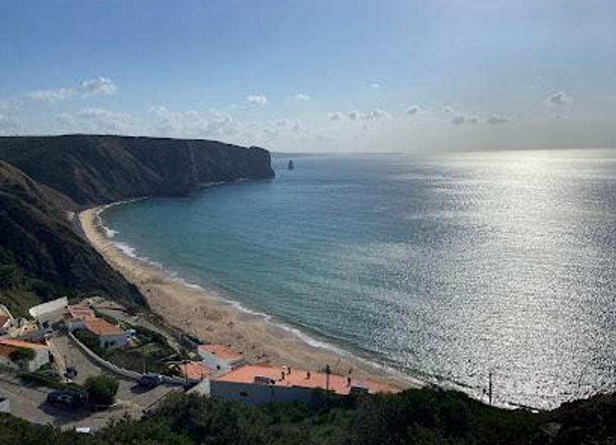 Experience the breathtaking beauty of Praia da Arrifana, a coastal paradise where golden sands meet dramatic cliffs in Portugal.