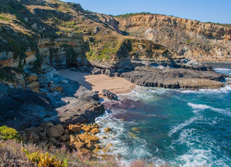 Explore the serene beauty of Praia do Rebenta Bois, a hidden beach paradise in Sesimbra, Portugal, perfect for relaxation and adventure.