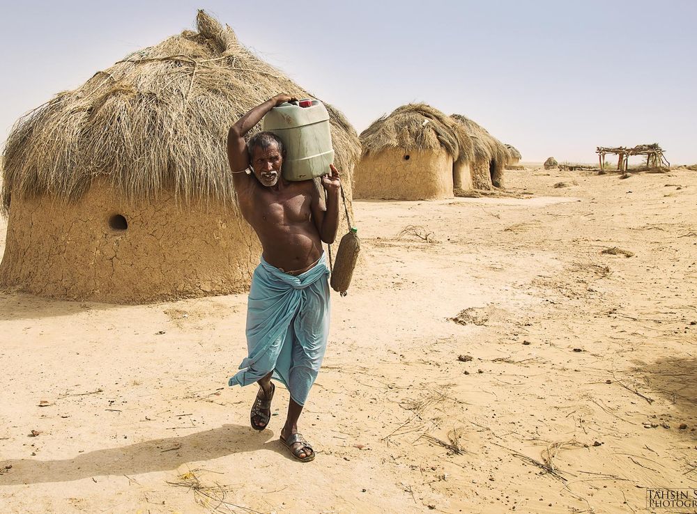 File:A semi-nomadic man carries water in the Cholistan Desert.jpg -  Wikimedia Commons