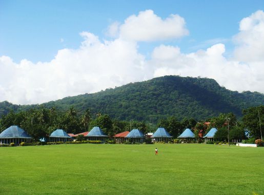 File:Round Samoan houses with blue roofs, Lepea village with Mt Vaea  beyond.JPG - Wikimedia Commons