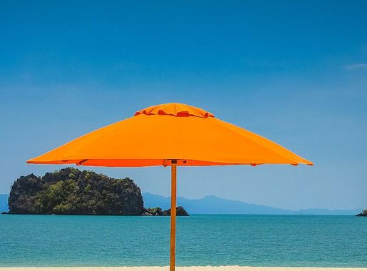 Royalty-Free photo: Two beach loungers under orange umbrella at seashore  under blue calm sky | PickPik
