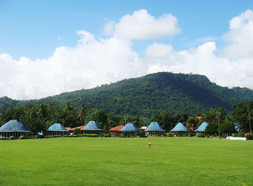 File:Round Samoan houses with blue roofs, Lepea village with Mt Vaea  beyond.JPG - Wikimedia Commons