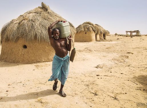 File:A semi-nomadic man carries water in the Cholistan Desert.jpg -  Wikimedia Commons