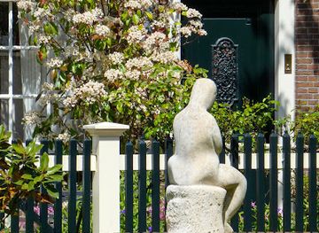 netherlands/amsterdam/centrum/landmark/sculpture-zittende-vrouwenfiguur-met-gekruiste-armen