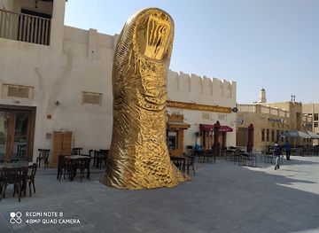 qatar/doha/souq-waqif/landmark/the-golden-thumb-statue