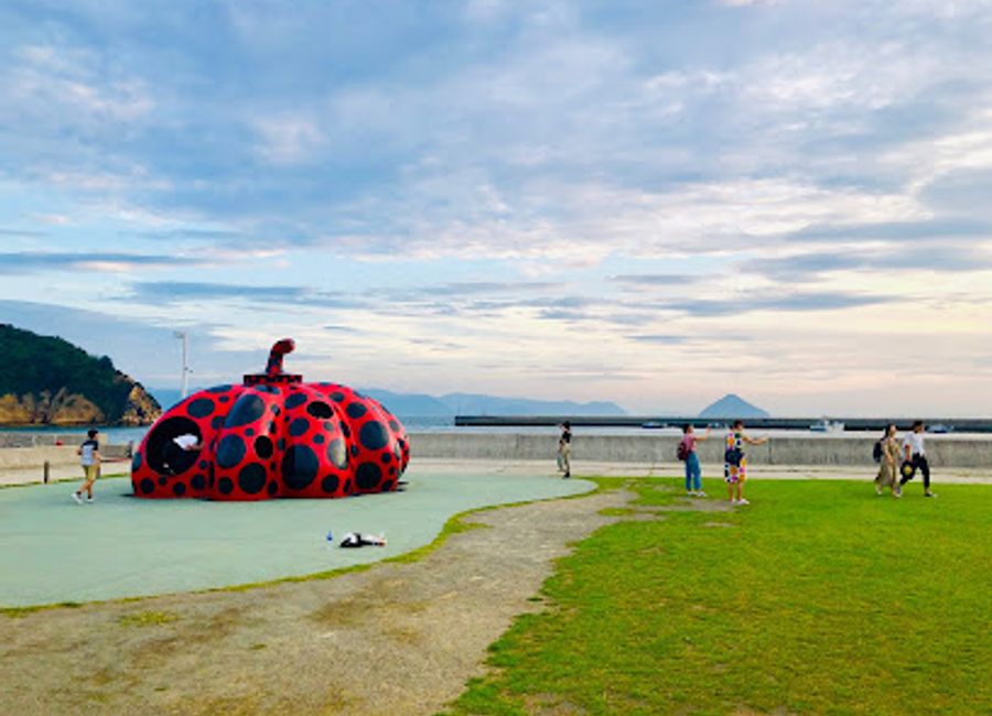 Explore the vibrant Red Pumpkin in Naoshima, a masterpiece of contemporary art by Yayoi Kusama, set against stunning coastal views.
