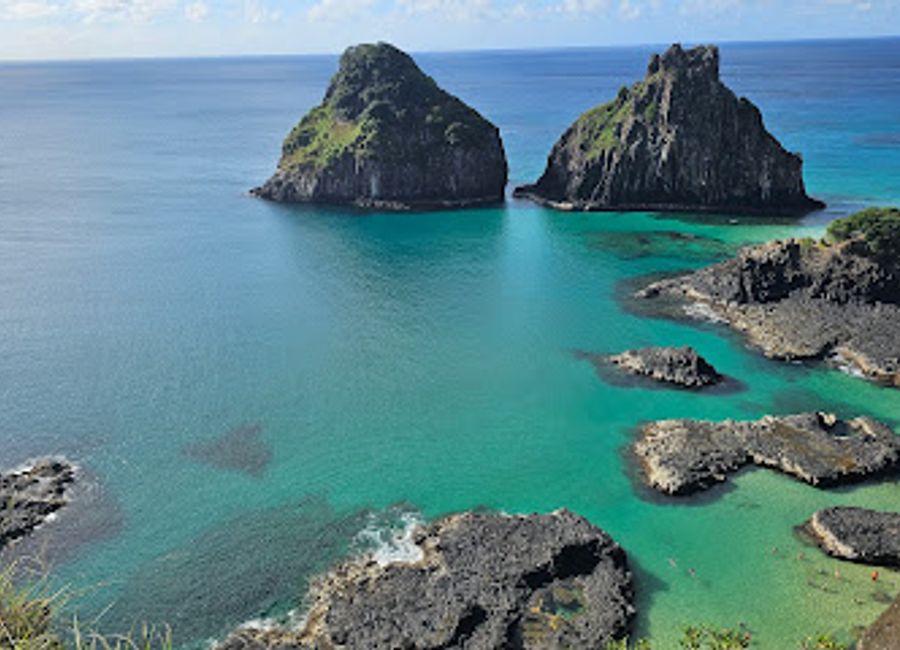 Discover Baía dos Porcos: a secluded beach with dramatic volcanic scenery, crystal-clear waters, and unforgettable views in Fernando de Noronha.