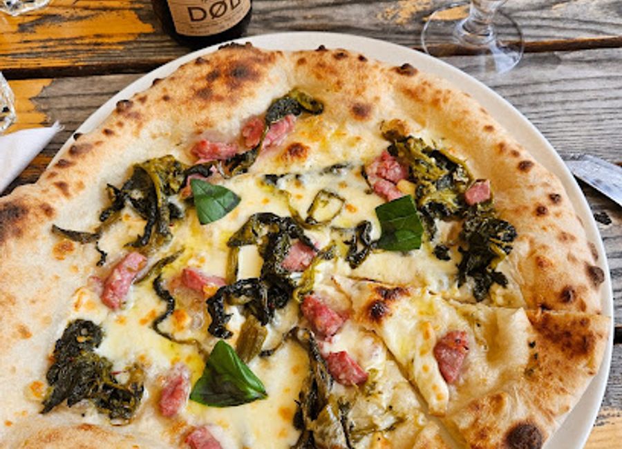 Experience authentic Norwegian pizza at Bakeriet i Lom Uteservering - where flavor meets stunning natural beauty.