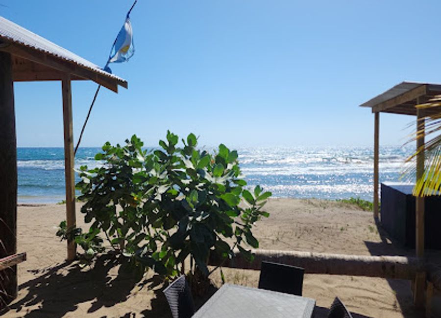 Experience vibrant Jamaican flavors at Ki's on di Beach - a coastal grill paradise in Treasure Beach offering stunning views and delicious local cuisine.