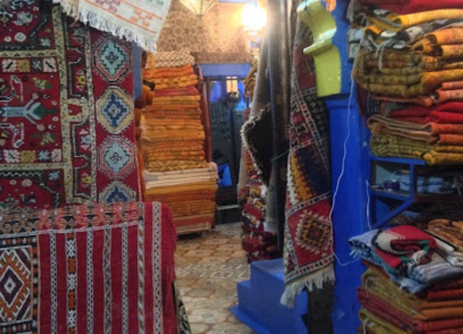 Explore the vibrant artistry of handcrafted rugs in Chefchaouen's enchanting rug shop, a treasure trove of Moroccan culture.